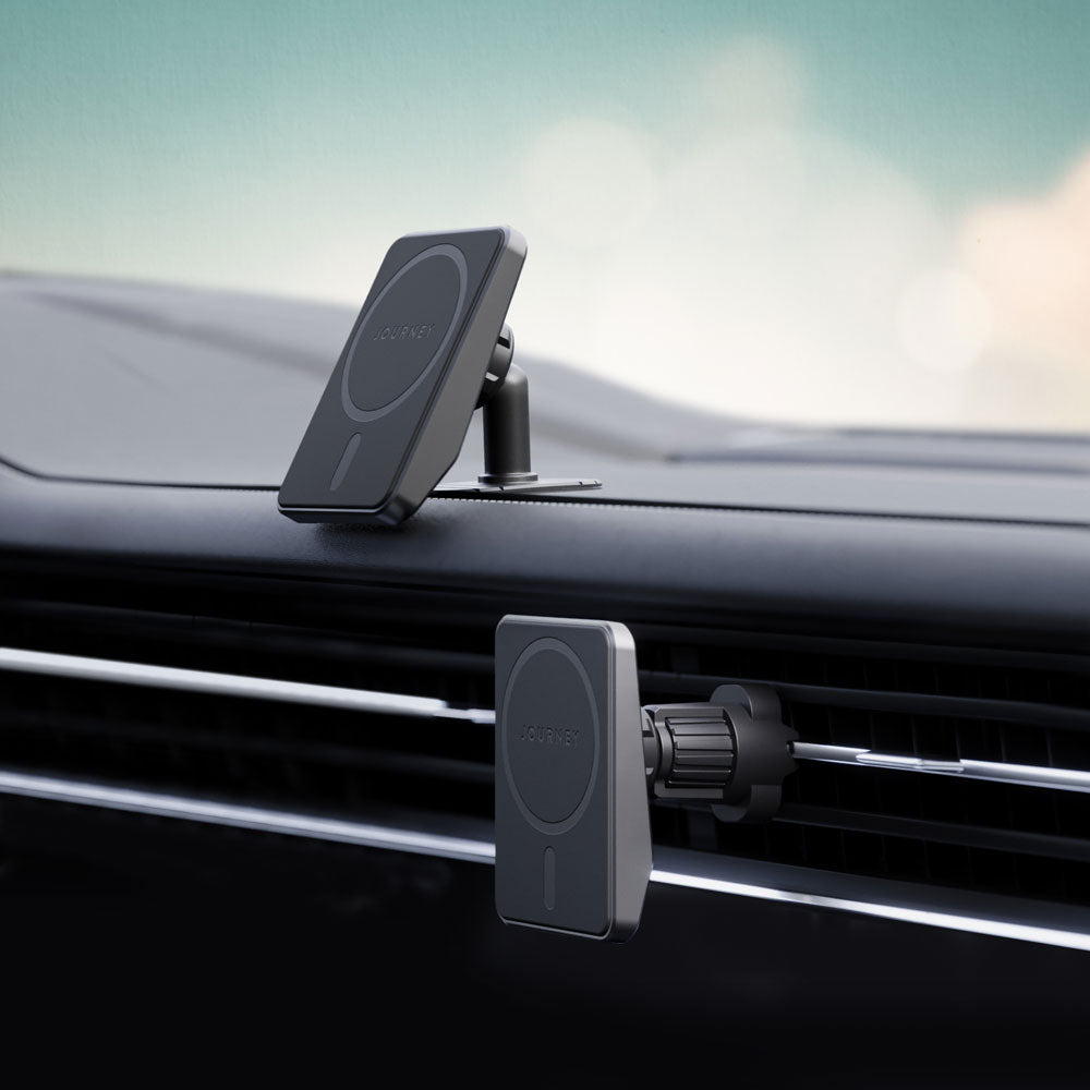 Two car phone holders on a car dashboard with a blurred outdoor background