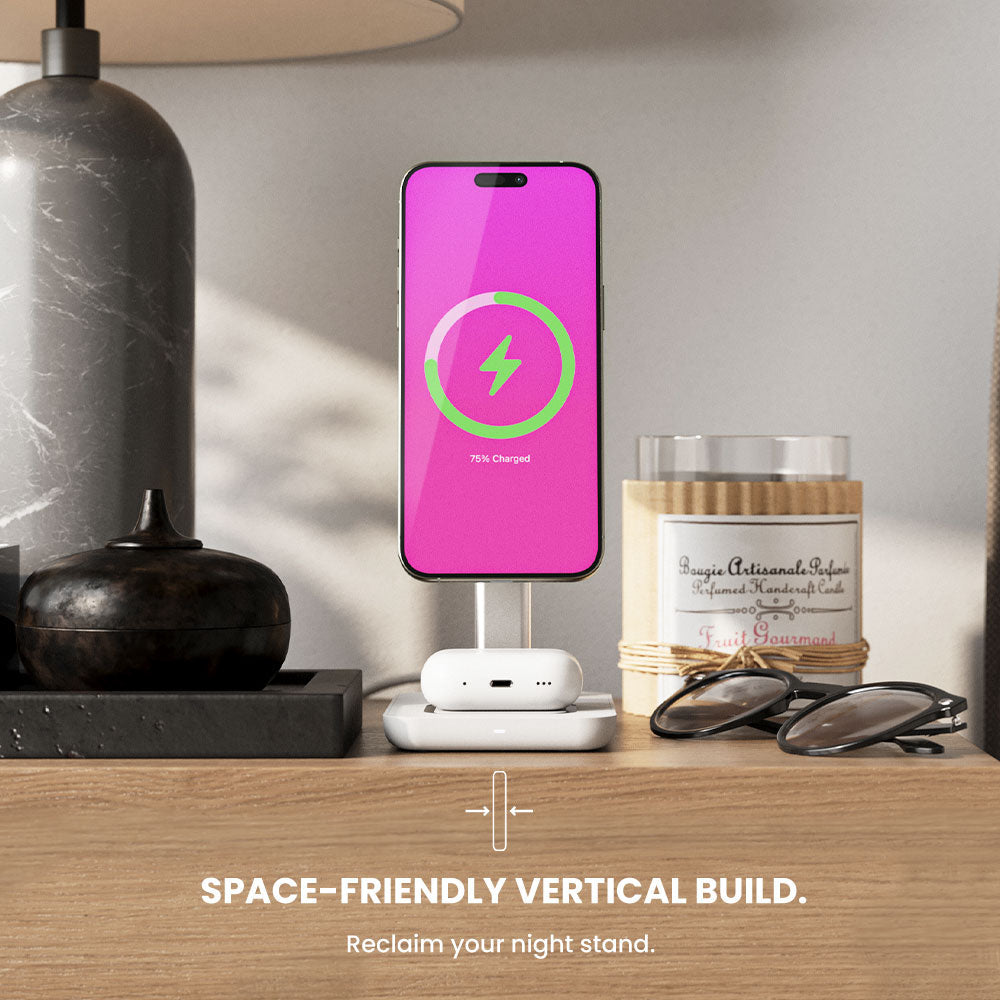 Phone on a stand with a pink screen displaying a charging icon, placed on a nightstand.