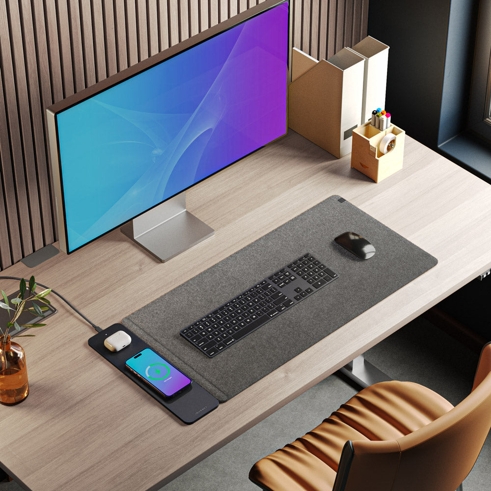 Modern office desk setup with computer monitor, keyboard, mouse, and phone on a wooden desk.