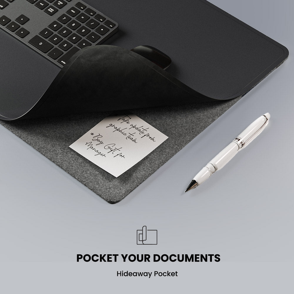Gray desk mat with a keyboard, mouse, pen, and sticky note on a gray surface.