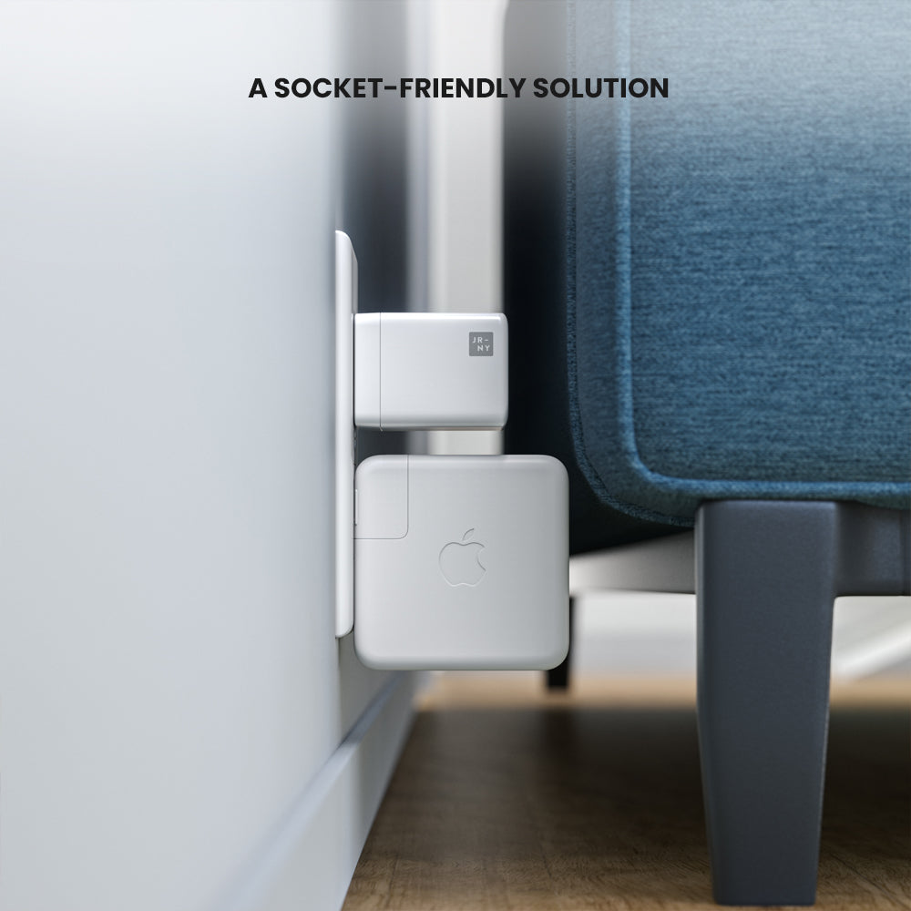 White charging cable adapter attached to a wall socket with a blue chair in the background.