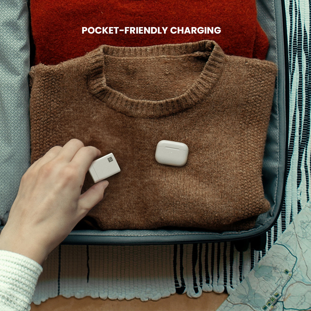 Folded brown sweater with a charging device on a suitcase, labeled 'Pocket-Friendly Charging'.