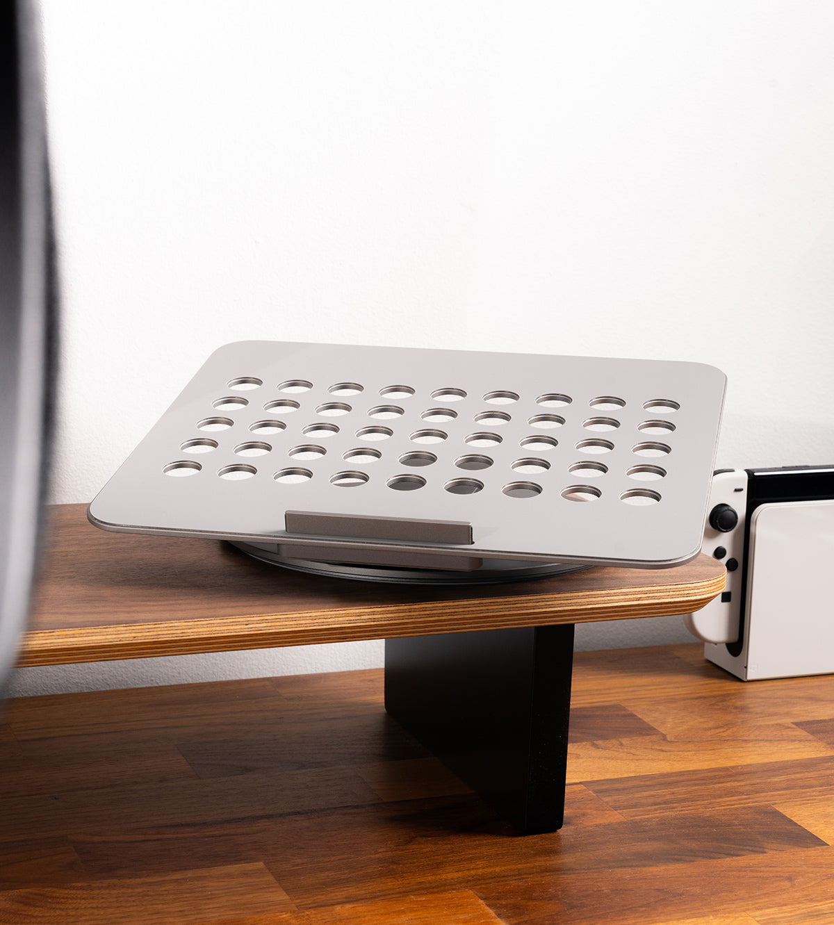 Laptop stand on a wooden desk with a white background