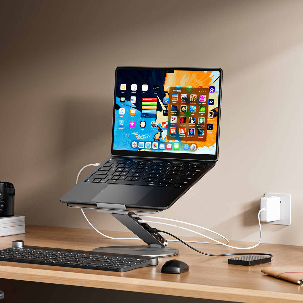 Laptop on a stand with multiple screens displaying colorful app icons on a wooden desk.