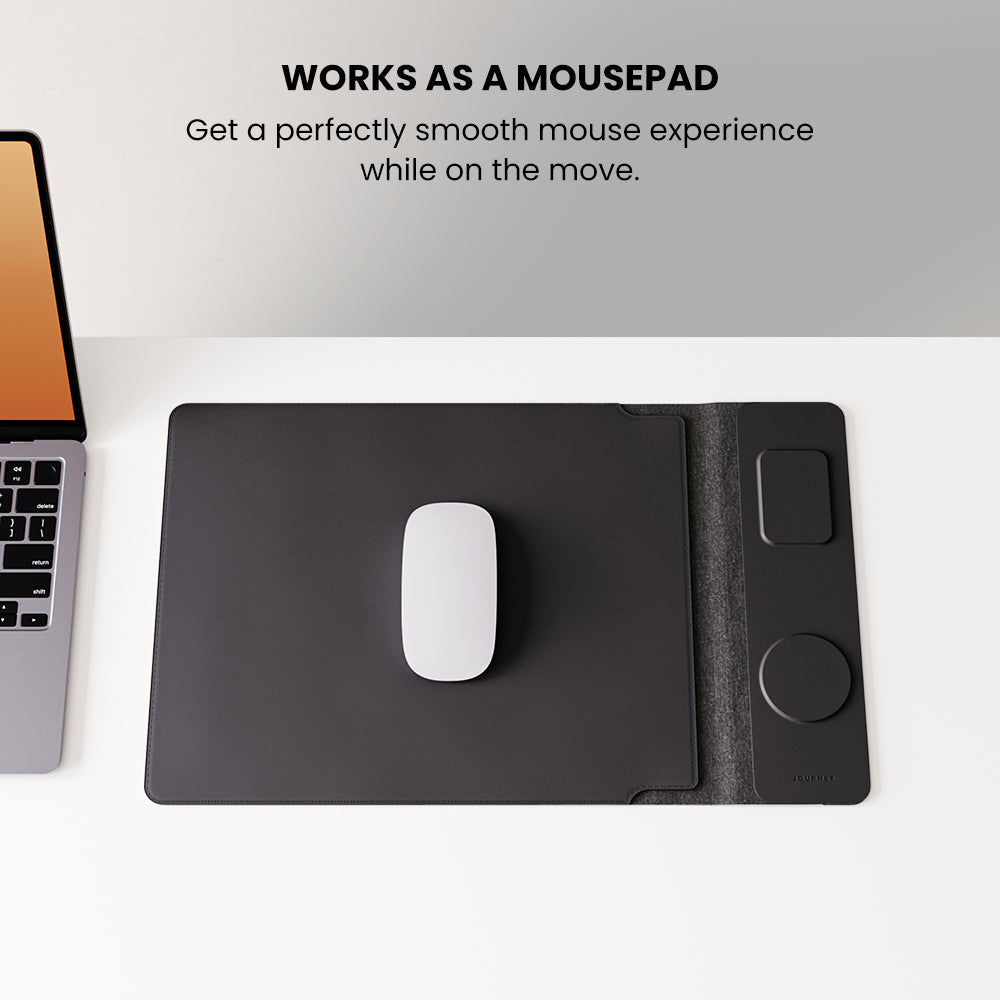 Black mouse pad with a white mouse on a desk next to a laptop, with text indicating it works as a mousepad.