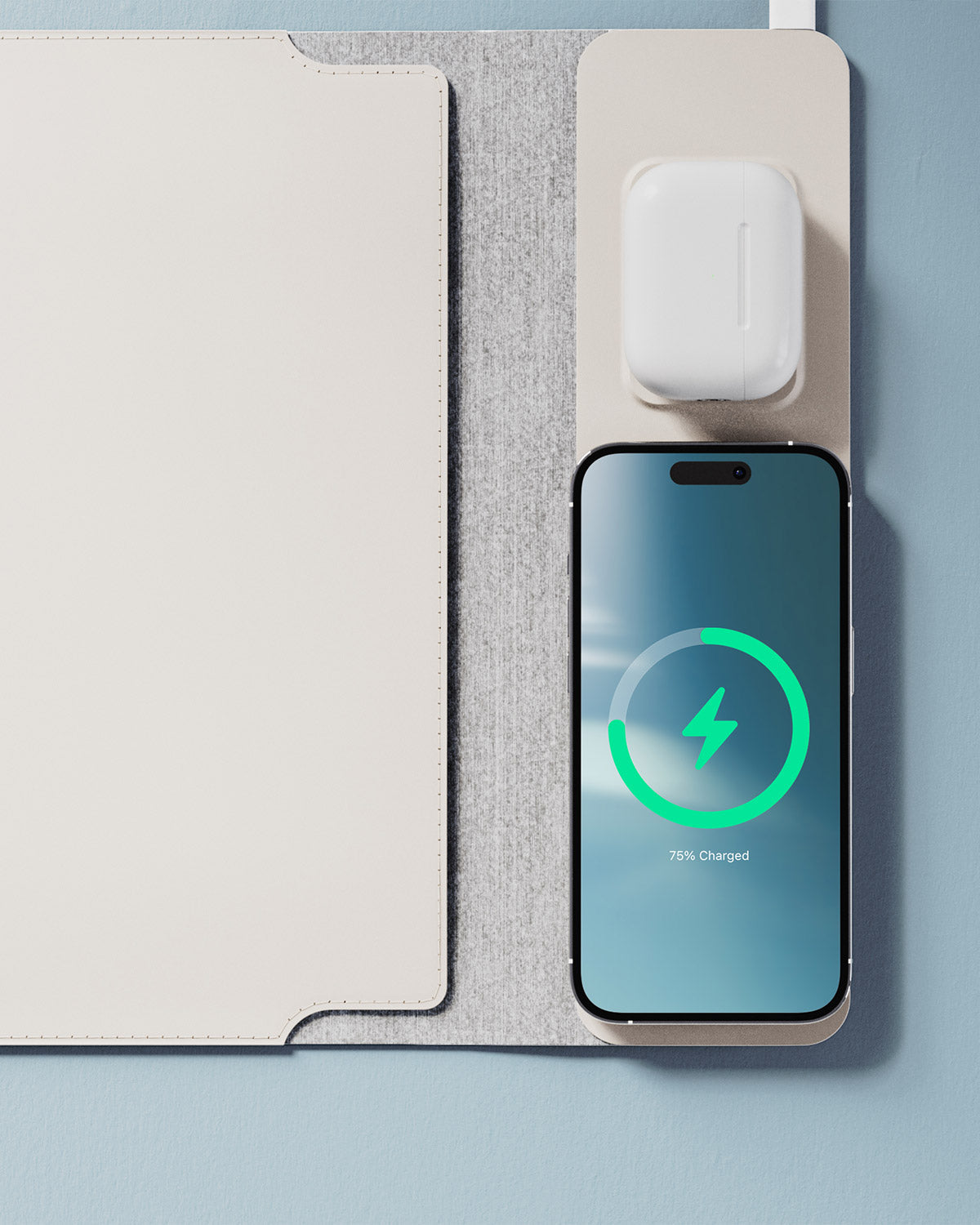 Smartphone with wireless charging pad and AirPods on a light gray surface