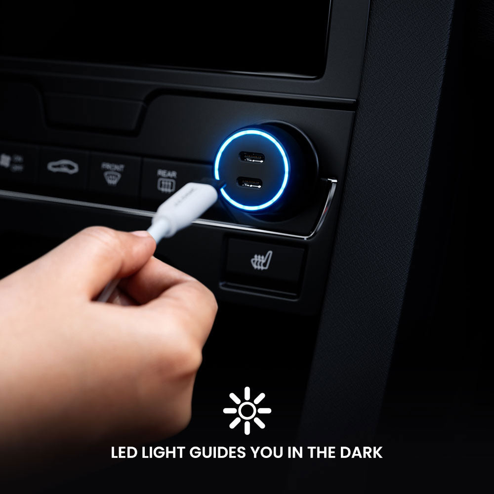 Hand plugging a cable into a car's USB port with LED light indicator.