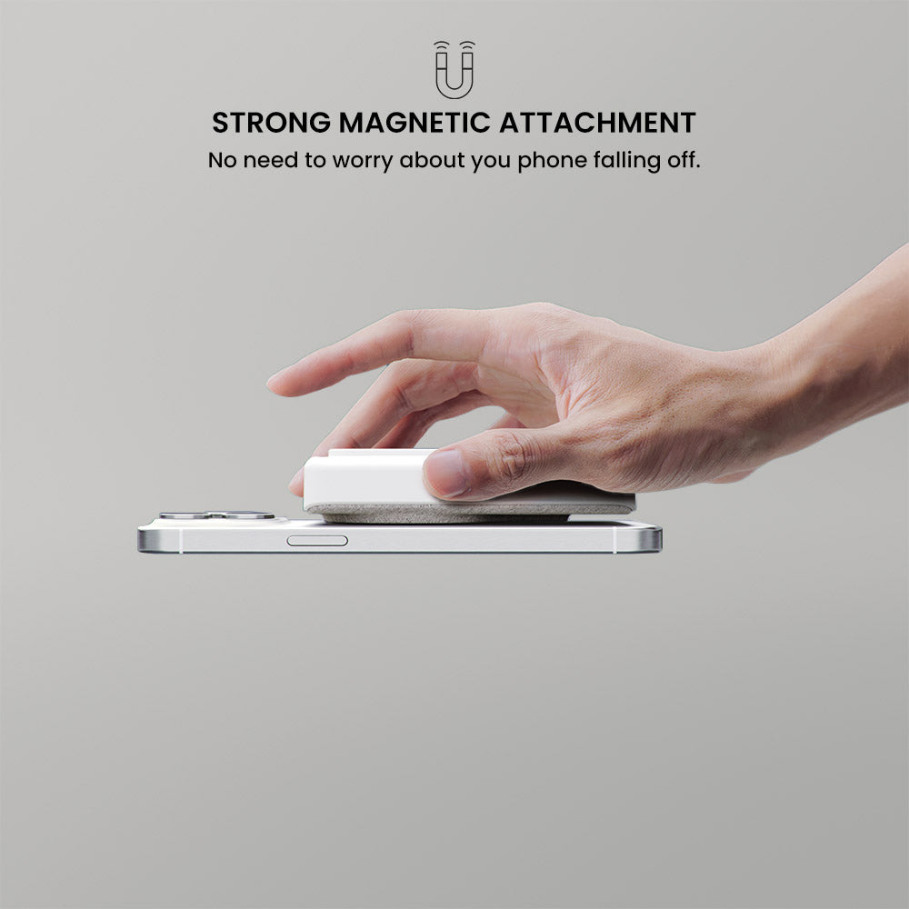Hand placing a phone onto a magnetic attachment device with text about strong magnetic attachment.