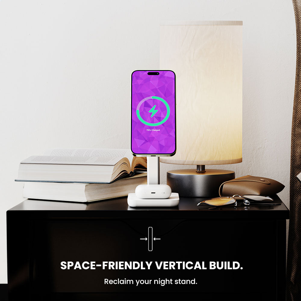 Smartphone on a stand with a purple screen on a nightstand next to a lamp and books.